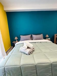 een slaapkamer met een groot bed en handdoeken bij Marios IsimeriaHomz in Thessaloniki