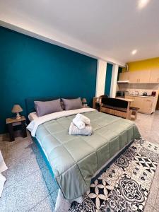 een slaapkamer met een groot bed met een blauwe muur bij Marios IsimeriaHomz in Thessaloniki
