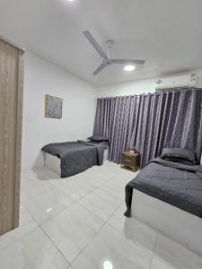 1 dormitorio con 2 camas y ventilador de techo en كورنيش عجمان, en Ajman