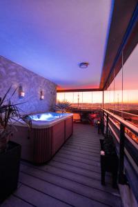 Luxury penthouse with Kosice view في كوشيتسه: حوض استحمام ساخن على شرفة المبنى