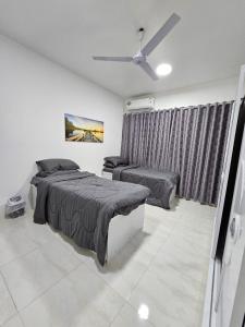 a bedroom with two beds and a ceiling fan at كورنيش عجمان in Ajman 