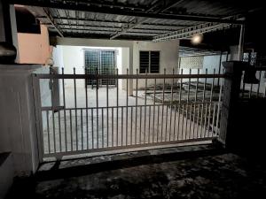 an open gate in a room with a fence at Simple Beseri Homestay in Kangar