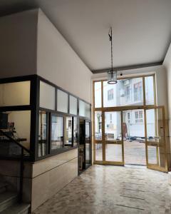 een lege kamer met een grote glazen deur en een kamer met bij IANOS Apartment Naples in Napels