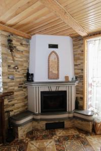 Cottage "Karpatske Shale" في ياريمتشي: مدفأة في غرفة بجدار خشبي