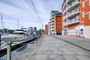 a boat docked at a marina next to a building at Stylish 2 Bedroom Apartment on the Waterfront in Ipswich