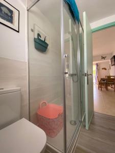 a bathroom with a shower with a toilet and a basket at Tramontana Villa in Cala'n Porter
