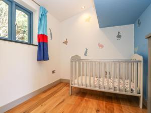 - une chambre bébé avec un lit bébé et un plafond bleu dans l'établissement Nordstrom, à Truro