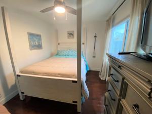 Habitación pequeña con cama y ventana en Bay Beach Bungalow en San Diego