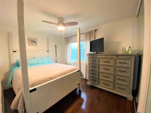 1 dormitorio con 1 cama y vestidor con TV en Bay Beach Bungalow en San Diego