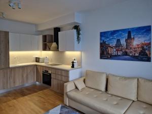 a living room with a couch and a kitchen at Vltava apartments in Prague
