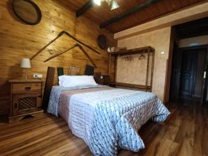 a bedroom with a bed and a wooden wall at Cornatel Médulas in Borrenes