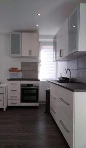 a kitchen with white cabinets and a black counter top at Duplex Tressange in Tressange +7 photos