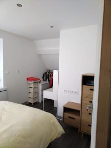 a bedroom with a bed and a dresser and a desk at Duplex Tressange in Tressange
