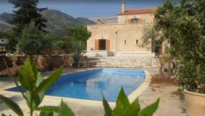 Villa con piscina frente a una casa en Villa Ariadne en Melidhónion