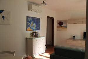 sala de estar con armario blanco y sofá verde en sweet home la maddalena en La Maddalena