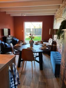 a dining room with a table and a couch at Guesthouse by C in Colijnsplaat