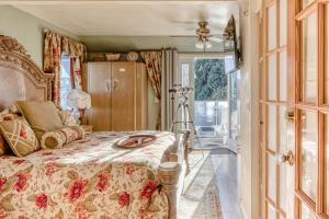 a bedroom with a bed with a floral bedspread at The Victorian Spa Retreat in Port Angeles