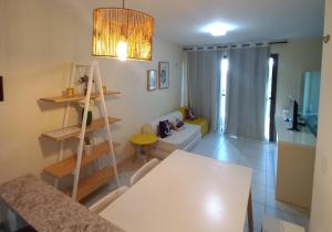 卡姆布庫的住宿－Escala VG Sun Cumbuco，一间带白色桌子的客厅和一间带沙发的房间