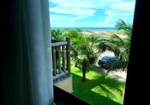 a balcony with a view of the beach and a car at Escala VG Sun Cumbuco in Cumbuco