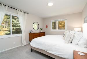 ein Schlafzimmer mit einem Bett und zwei Fenstern in der Unterkunft Carlow Manor in Mound