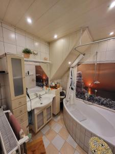 a bathroom with a tub and a sink and a bath tub at Ferienwohnung Haus Luzia in Düngenheim