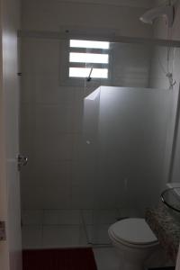 baño con ducha, aseo y ventana en Recanto aconchegante no Campeche Apart 02 - 50m da praia -, en Florianópolis