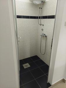 y baño con ducha y suelo de baldosa blanco y negro. en Apartman Aleksić u samom centru grada en Knjazevac.