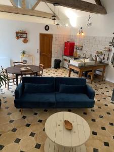 een woonkamer met een blauwe bank en een tafel bij Maison - Ancien Chai in Turquant