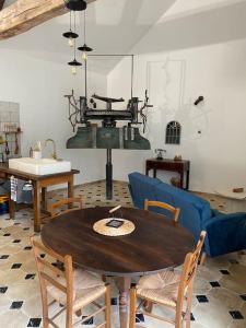 een woonkamer met een tafel en stoelen en een wastafel bij Maison - Ancien Chai in Turquant