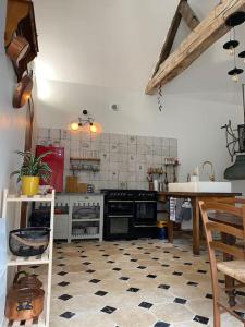a kitchen with black appliances and a checkered floor at Maison - Ancien Chai in Turquant