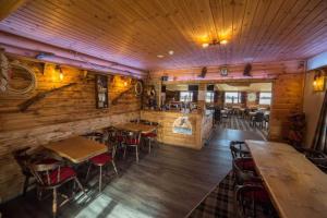 a restaurant with wooden walls and tables and chairs at Unwind@36 Lodge in Felton