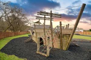 a playground with a slide and a swing at Unwind@36 Lodge in Felton