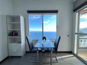 d'une salle à manger avec une table, des chaises et une fenêtre. dans l'établissement Casa Vista Pájaro, à Puntallana