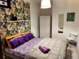 Un dormitorio con una cama con almohadas moradas. en La Dimora Fiorita, en Catania