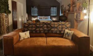 um sofá de couro castanho numa sala de estar em The Bothy em Stirling