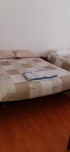 duas camas sentadas uma ao lado da outra num piso de madeira em Apartamento Abril em Gouveia