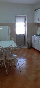 a table and chairs in a room with a kitchen at Apartamento Abril in Gouveia