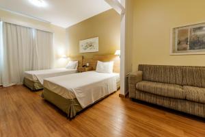 カンピーナスにあるIbis Styles Campinas Alphavilleのベッド2台とソファがあるホテルの部屋