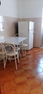 a kitchen with a table and chairs and a refrigerator at Apartamento Abril in Gouveia