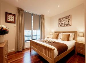 a bedroom with a bed and a large window at Farringdon Laceby apartments in London