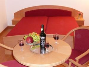 a table with a bottle of wine and two glasses at BALATON ART Guesthouse in Balatonszemes