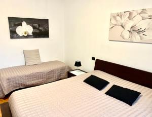een slaapkamer met 2 bedden en een schilderij aan de muur bij Top Apartment in Beccacivetta