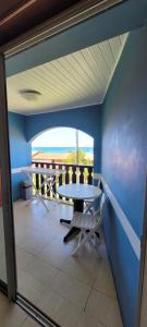 a table and chairs in a room with a view of the ocean at Turquoise Caritan in Sainte-Anne