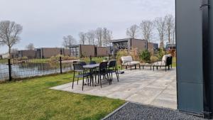 a patio with chairs and a table and chairs at Velduil 52 in Hulshorst