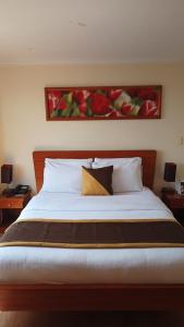 1 dormitorio con 1 cama con una pintura en la pared en Hotel Splendor by Friends Company, en Bogotá