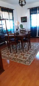 ein Esszimmer mit einem Tisch und Stühlen auf einem Teppich in der Unterkunft Apartamento Abril in Gouveia