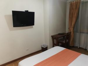 1 dormitorio con 1 cama y TV de pantalla plana en la pared en Hotel Splendor by Friends Company, en Bogotá