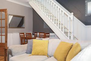 a living room with a couch and a staircase at Beautiful Rooms in Edinburgh Cottage Guest House - Free Parking in Edinburgh