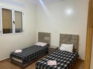 - une chambre avec 2 lits dans l'établissement Appartement à louer, à Larache