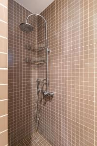 a shower in a bathroom with brown tile at Something different in Chalkida in Kánithos